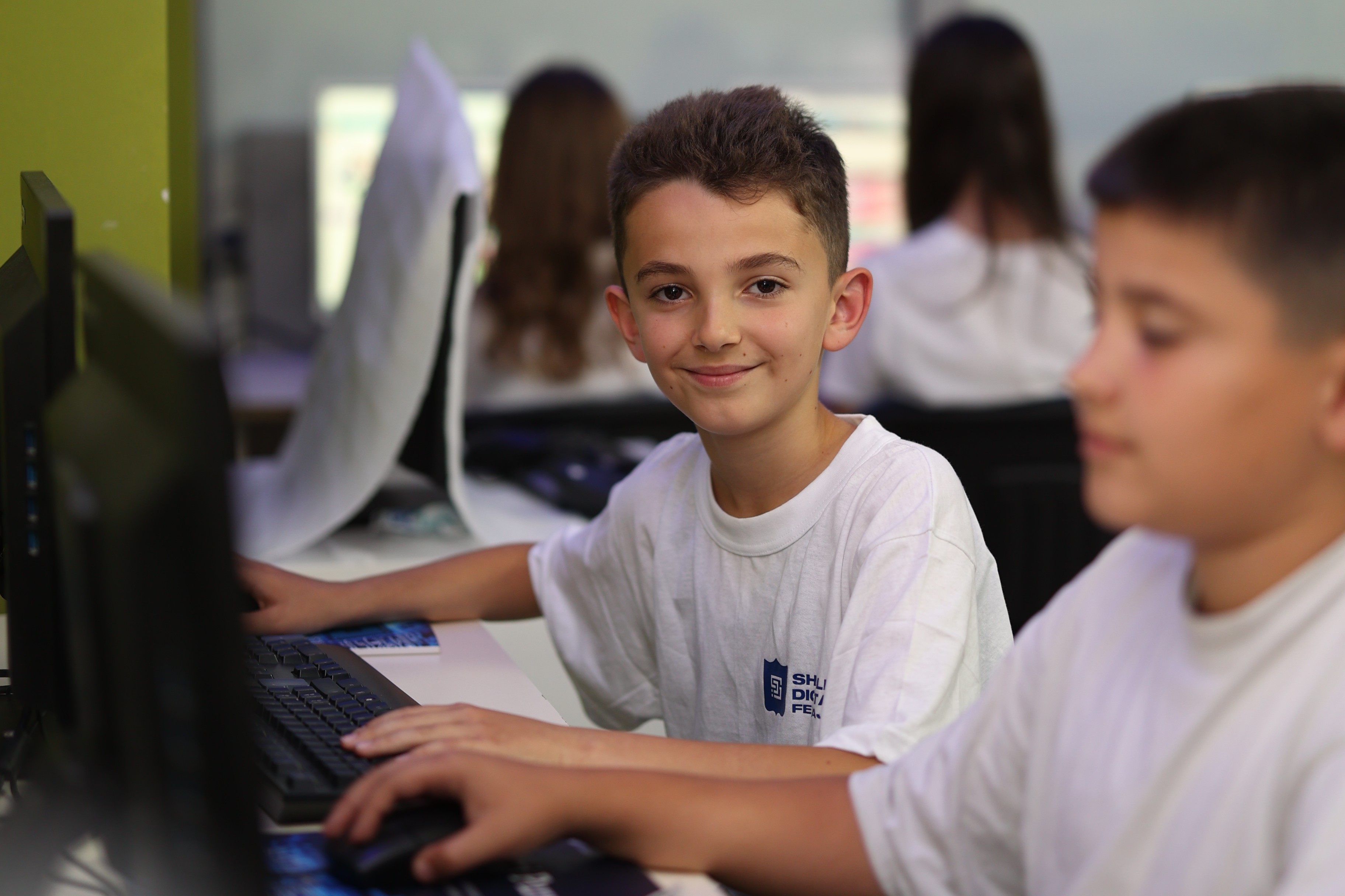 Fëmijë duke mësuar programim në laborator kompjuterik